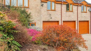 A stone house with multiple windows and a garage. - Stonecroft Lodge (Belper)