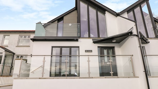 A modern two-story residential building with large windows, a balcony, and a nameplate reading "Mør Avelon". - Mor Awelon (Goodwick)