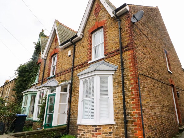 A two-story brick house with white window shutters and a bay window. - Newden Cottage (Whitstable)