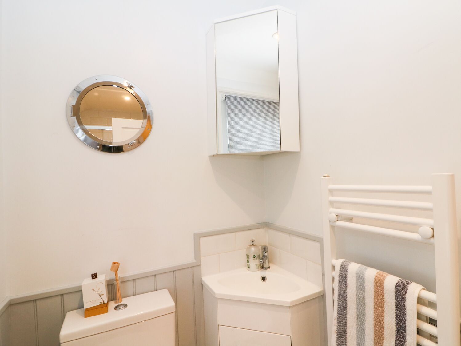 Une salle de bain équipée de toilettes, d’un lavabo et d’un porte-serviettes.