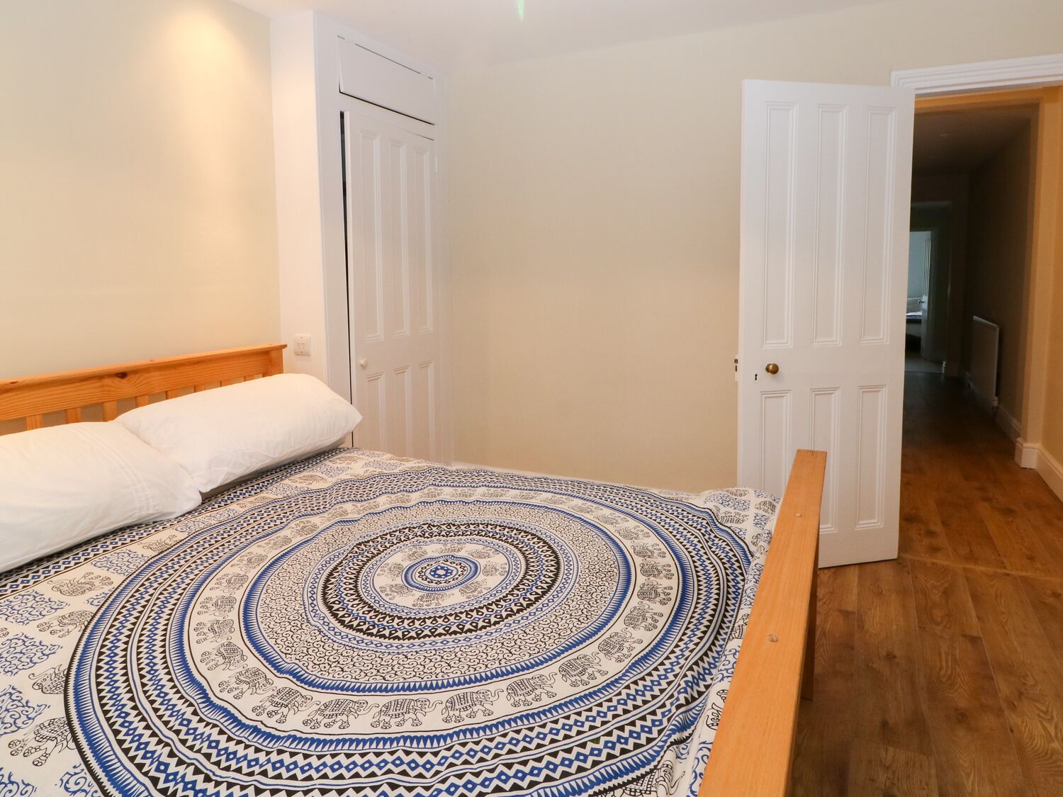 Une chambre à coucher avec un lit, un tapis à motifs et une tête de lit en bois.