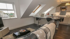 A modern loft apartment with a living area, kitchenette, and a dining space. - 5 Old Laundry Mews (Carnforth)