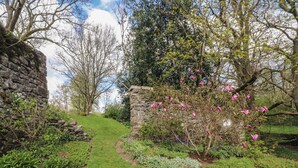 A stone wall, a grassy path, and flowering trees. - 2 Riverside Walk (Skipton)