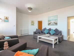 A modern living room with a sofa set, a coffee table, and a painting on the wall. - 38 The Parade (Walton on the Naze)