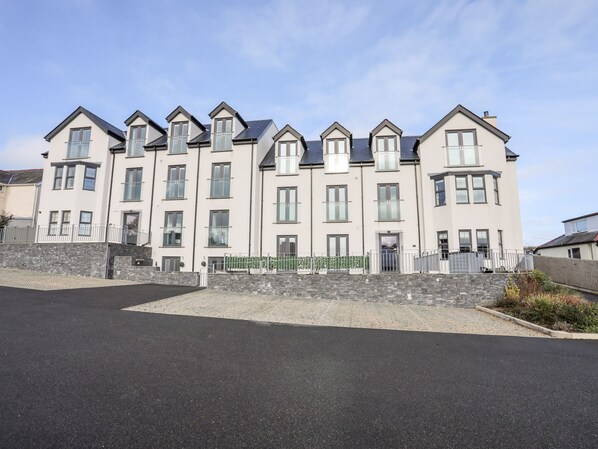 A multi-story residential building with a symmetrical facade, large windows, and a central entrance.