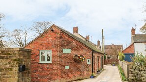 Een gebouw van baksteen met een stenen muur, een brievenbus en een bloembak aan de muur.