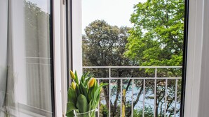 A window with a clear view of a balcony and a vase with flowers on the windowsill. - 3 Melbury (Salcombe)