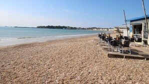 A pebble beach with a restaurant and outdoor seating. - Fenders (Weymouth)