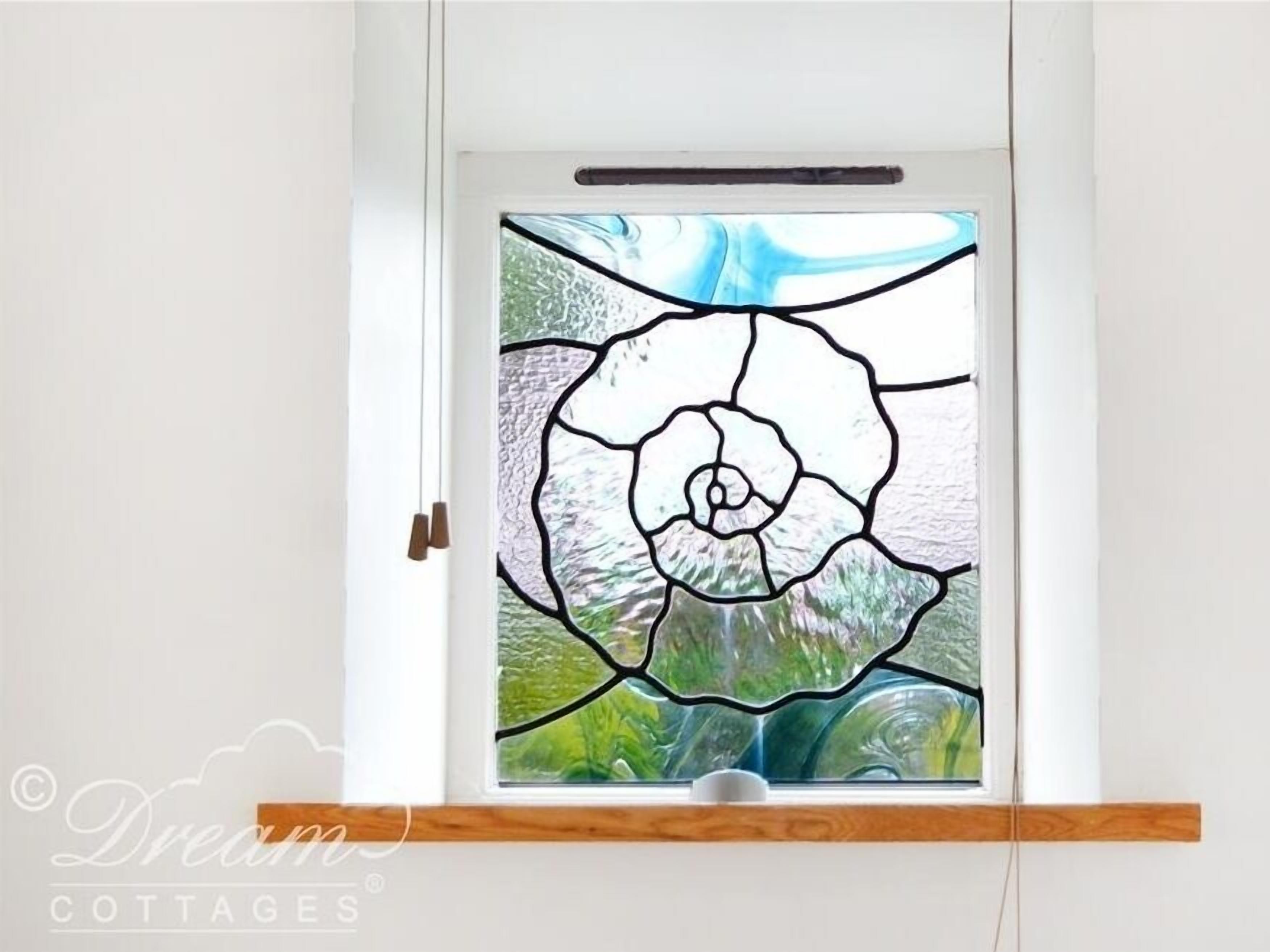 A window with a stained glass design of a flower.