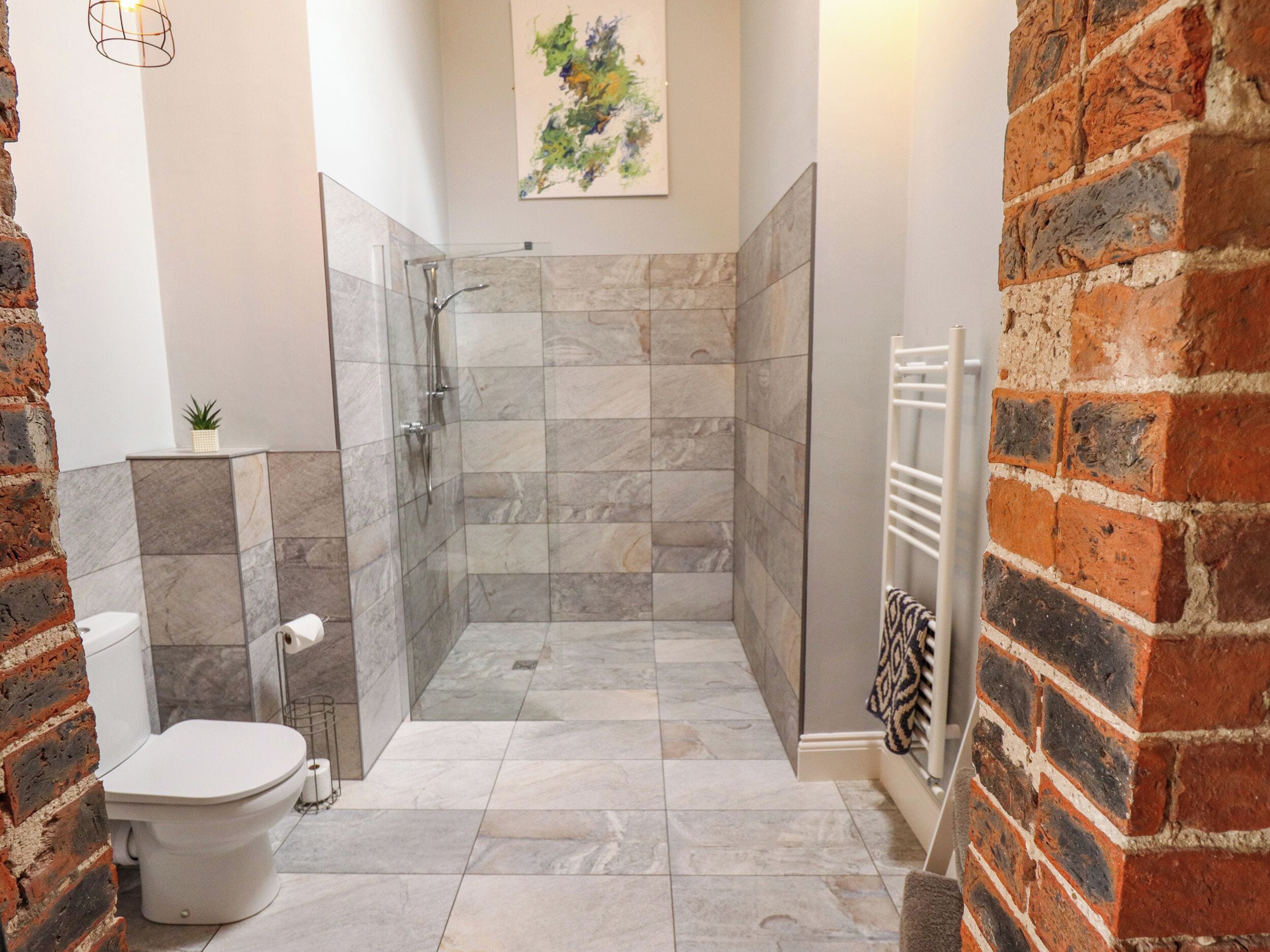 Ein Badezimmer mit Dusche, Toilette und Handtuchhalter.