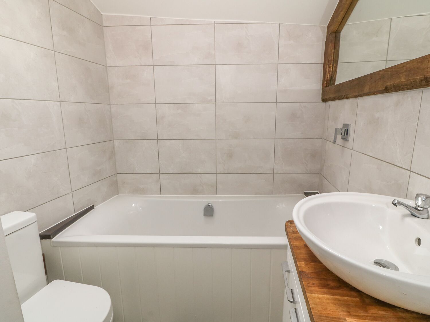 Un baño con bañera, inodoro y lavamanos.