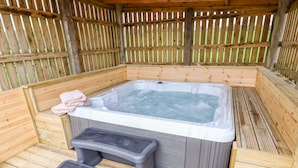 A wooden hot tub with a built-in bench and a step stool, surrounded by a wooden fence. - Woodthorpe Cruck Cottage (Chesterfield)