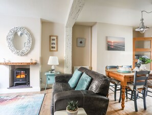 En hyggelig stue med pejs, spisebord og komfortabel sofa.