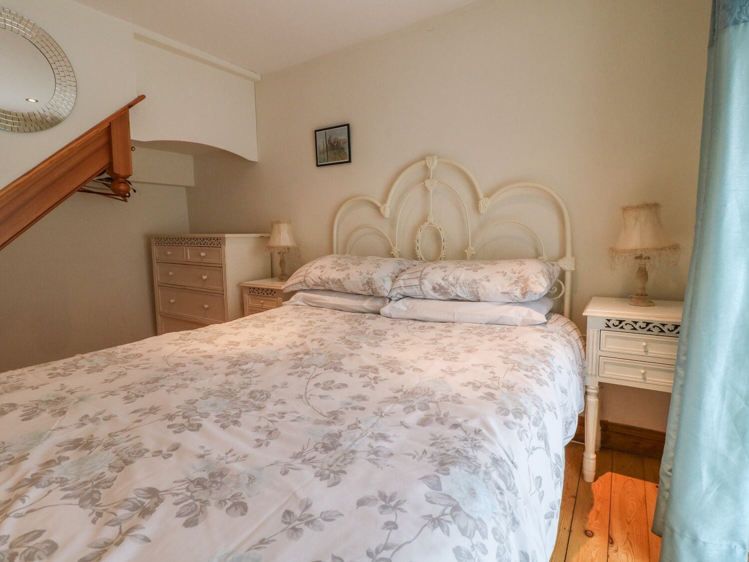 Un dormitorio con cama, cómoda, mesitas de noche y espejo.