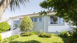 A two-story house with a well-maintained lawn and a variety of shrubs and small trees. - Keelyn (Newquay)