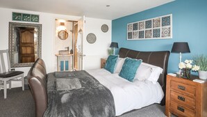 Une chambre à coucher comprenant un lit, des tables de chevet, une chaise, un miroir et des éléments décoratifs sur les murs.