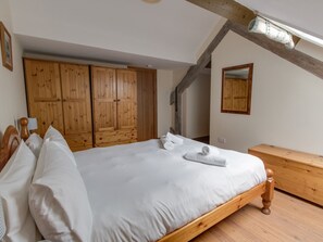 A bedroom with a wooden bed frame, a large wardrobe, and a wooden dresser. - George's House (Weymouth)