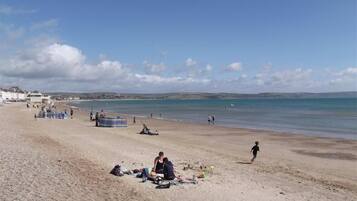 A beach with people relaxing and some tents set up.