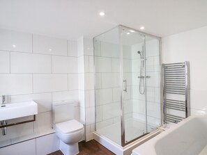 A modern bathroom with a glass-enclosed shower, a white toilet, and a bathtub. - George's House (Weymouth)