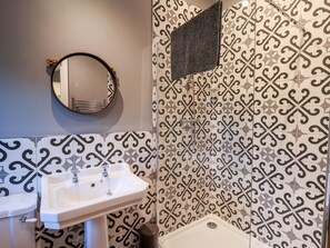 A bathroom with a white sink, a toilet, and a shower. - The Pheasantry (Scarborough)