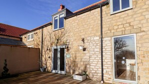 A stone building with a tiled roof, a door, and a window. - The Pheasantry (Scarborough)