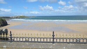 A beach with a clear sky and a fence in the foreground. - Chy-an-brae (Newquay)
