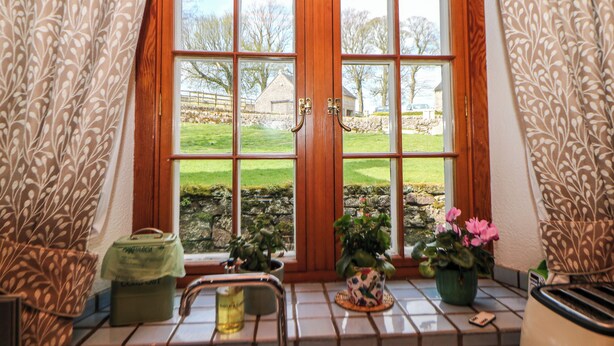 Una cocina con ventana, plantas en macetas y un tostador.