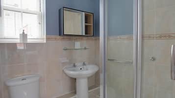 A bathroom with a toilet, sink, and shower.