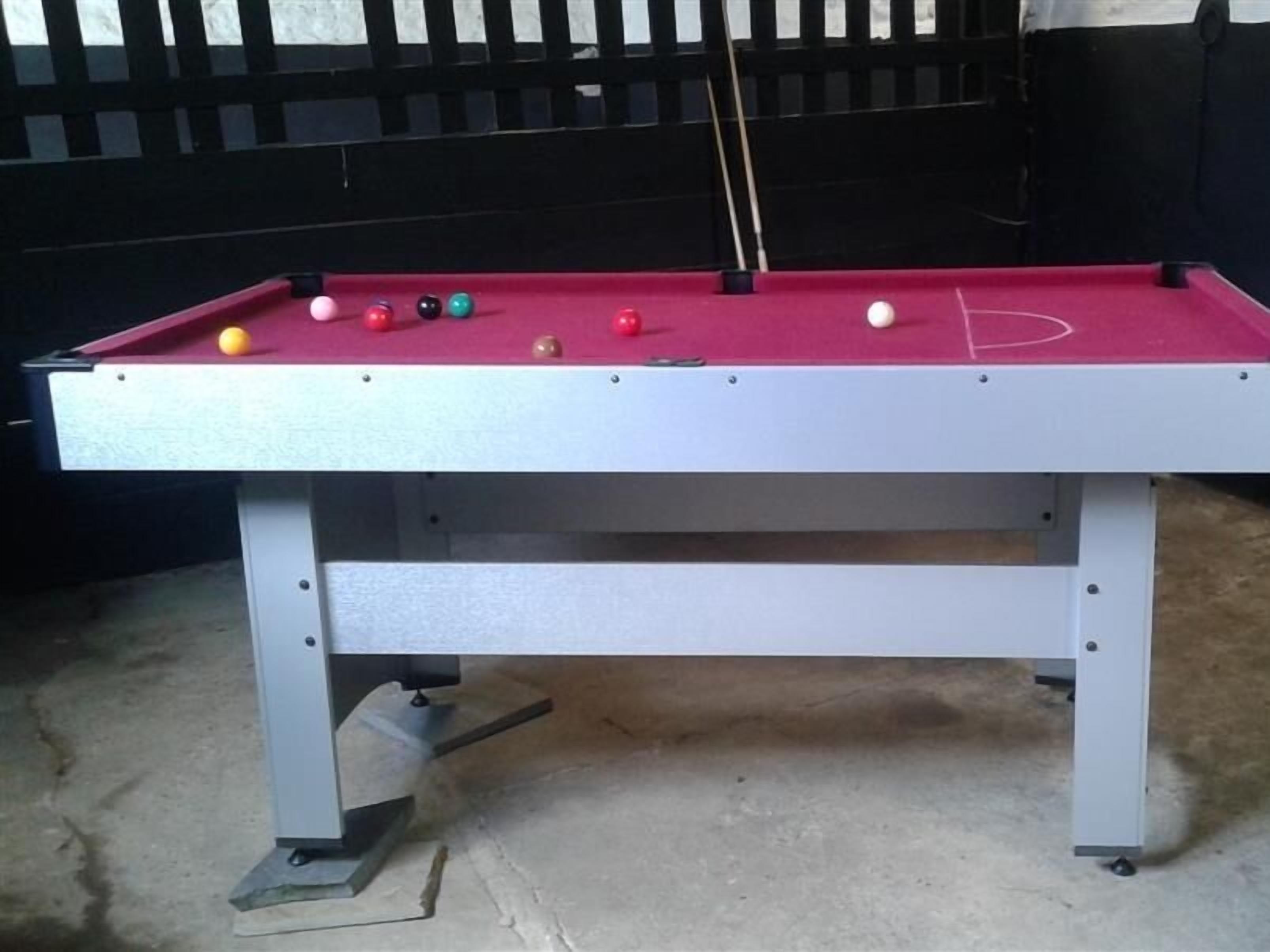 A pool table with balls and a cue stick.