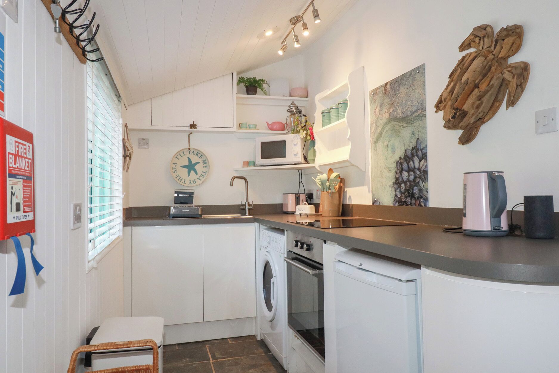 A compact kitchen with a washing machine, a microwave, and a sink.