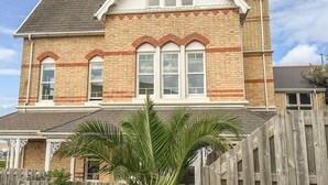 A two-story house with a brick facade, white trim, and a gabled roof. - Hartland View (Woolacombe)
