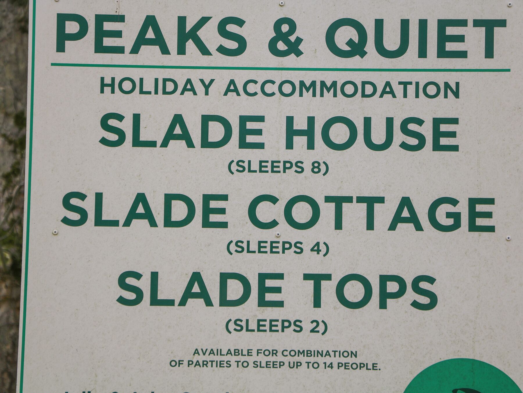 Segnaletica per Peaks & Quiet Holiday Accommodation che elenca Slade House, Slade Cottage e Slade Tops, con rispettivamente capacità di ospitare 8, 4 e 2 persone.