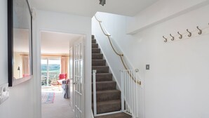 Eine Treppe mit weißer Geländer und Seilgeländer, die zu einem Balkon mit Aussicht führt.