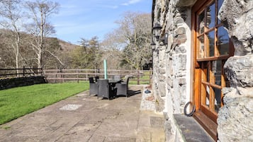 Experience the serene atmosphere of this charming stone building, featuring a patio area perfect for outdoor dining or relaxation.