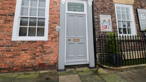 A brick building with a grey door labeled "Lovatt House." - Lovatt House Apartment Tynemouth (North Shields)