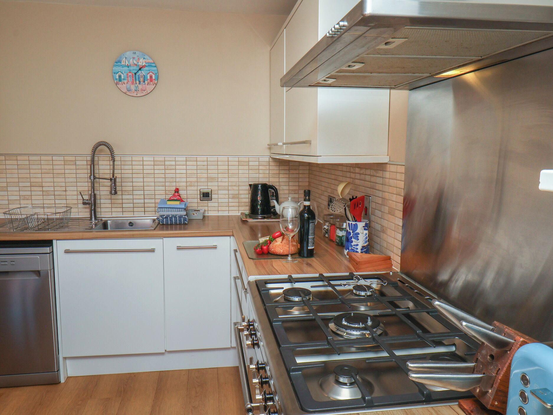 Een keuken met een fornuis, wastafel en kastjes.
