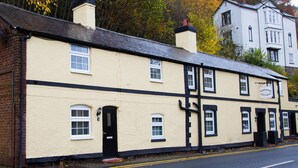 A two-story building with a sign reading "Waterloo Cottage." - Minafon (Llangollen)