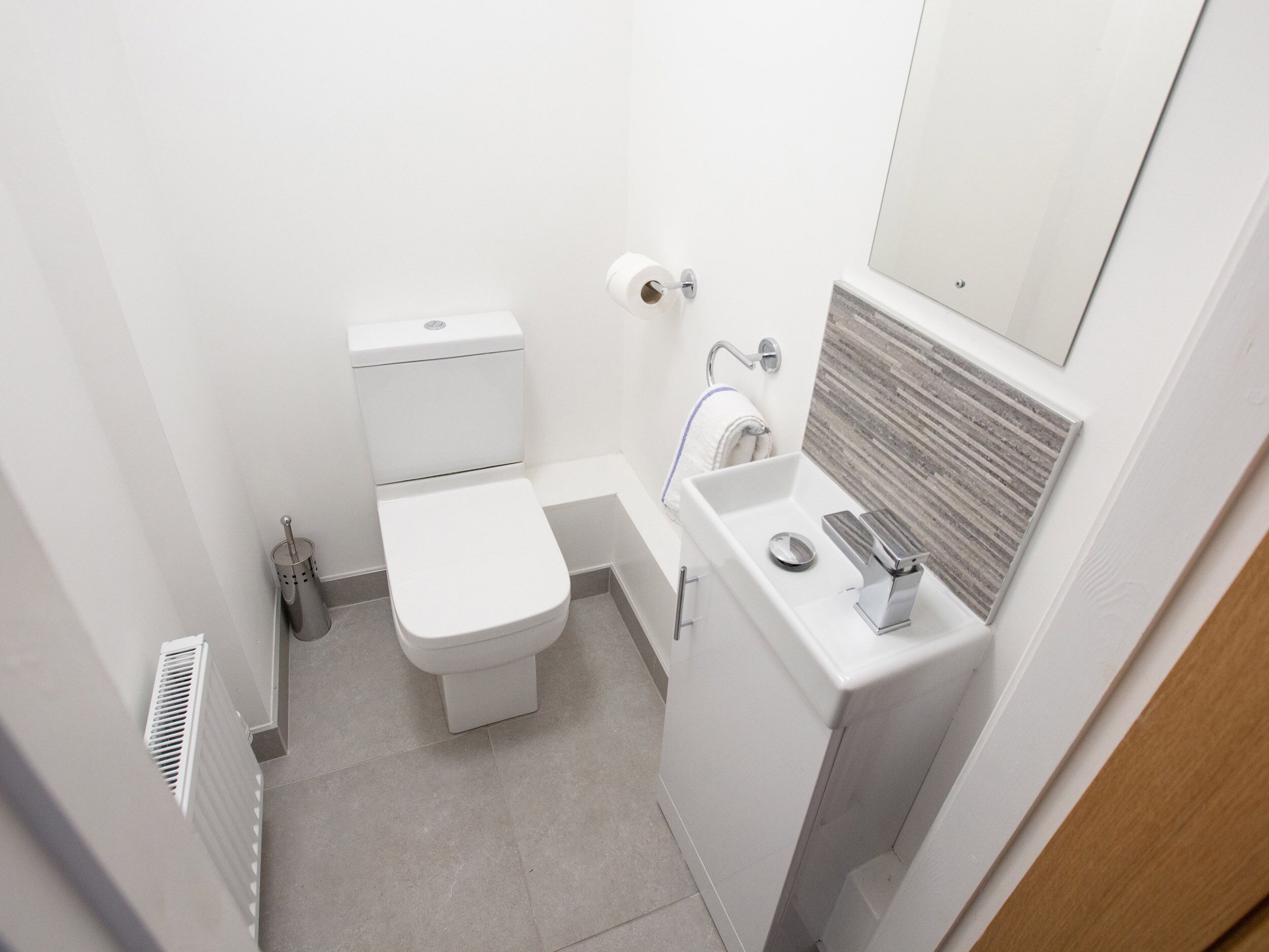 Un baño pequeño con inodoro, lavamanos y espejo.