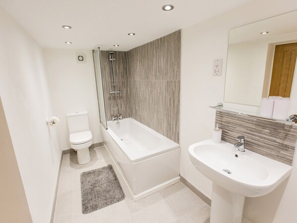 Un baño moderno con bañera, inodoro y lavabo.