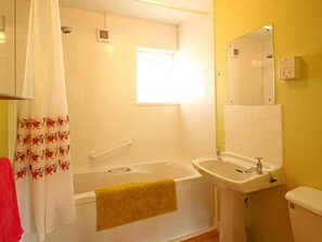 Un baño con bañera, lavabo e inodoro.