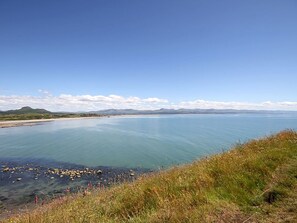 Un paisaje costero con una vista despejada del mar y montañas distantes.