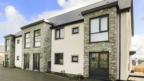 A row of modern two-story houses with stone facades and large windows.