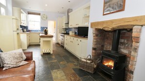 Eine moderne Küche mit Kamin, einem Essbereich und einem Wohnzimmer mit Sofa.