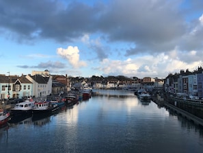 Boats dock along the water's edge, surrounded by a variety of buildings.