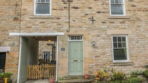 A stone building with a green door and two windows. - Hare &amp; Hounds House (Hexham)