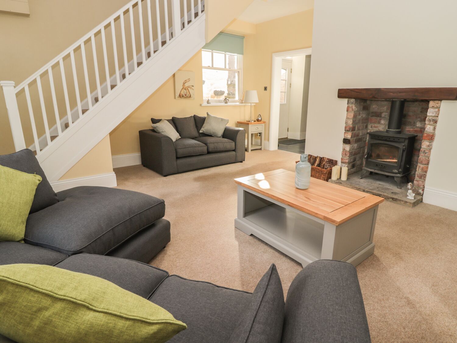 A living room with a staircase, a fireplace, and a sofa.