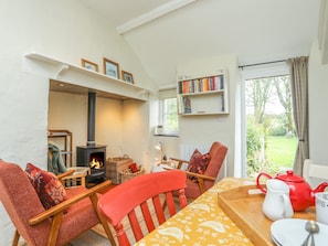 Cozy living room with a central fireplace, comfortable seating, and a bookshelf.