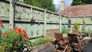 A wooden fence with decorative lights and a butterfly sculpture. - Greenham Cottage (Stoke-sub-Hamdon)
