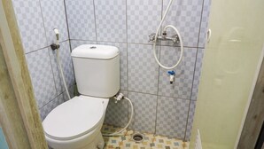 A small, compact bathroom with a toilet, a shower, and a sink. - OYO 2088 Grha Blue Sky Syariah (Bandung)