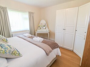 Relax in this serene bedroom with a large bed, bedside table, and elegant storage.